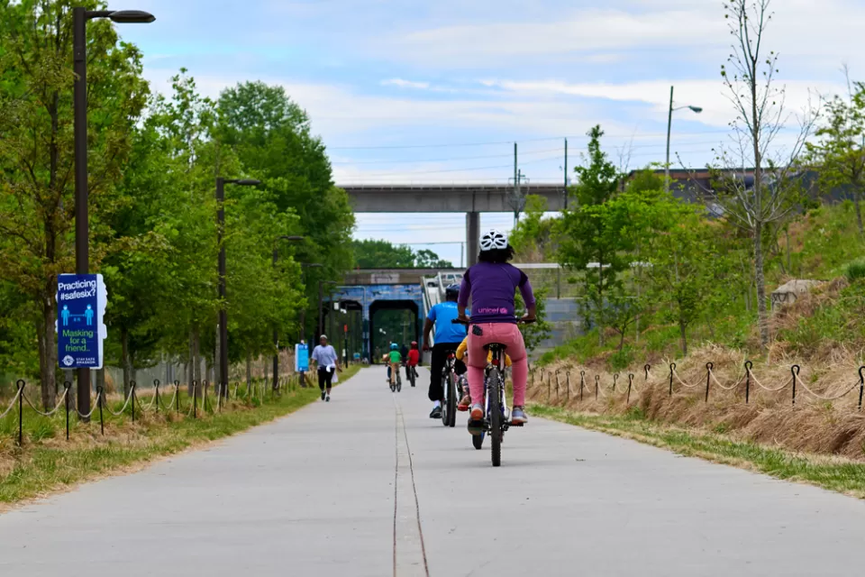 People on bikes ride along paved Atlanta BeltLine bike trail